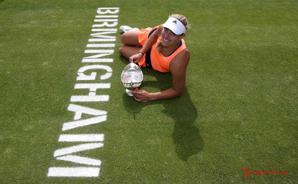 Angelique Kerber wins, then rests posing on the grass with her trophy beside "Birmingham" lettering. Credit: Porsche AG
