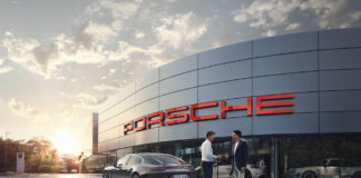 2019 Premier Porsche Dealers list announced 2019 Premier Porsche Dealers list announced: Pictured here is a Porsche dealership's facade at sunset, with the archetypical bold PORSCHE signage lit up in Guards Red. Credit: Porsche AG