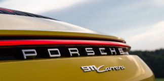 October 2019 USA sales October 2019 USA Sales: This photo is a tight shot of the rear “Porsche 911 Carrera” badging and illuminated continuous red taillight strip on a Racing Yellow 911. Credit: Porsche AG