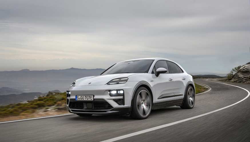 Depicted here is a white Porsche Macan EV Turbo, left-front corner, tooling along a twisty mountain road. Credit: Porsche AG