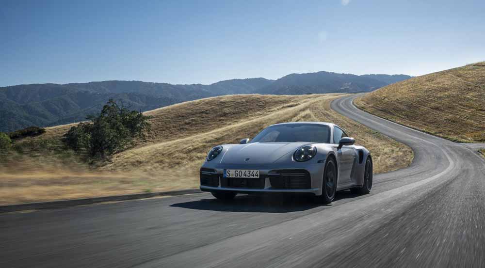 Introducing the Porsche 911 Turbo 50 Years model: Depicted here is a 911 Turbo 50 Years model, left-front, tooling along a windy road. Credit: Porsche AG. Credit: Porsche AG