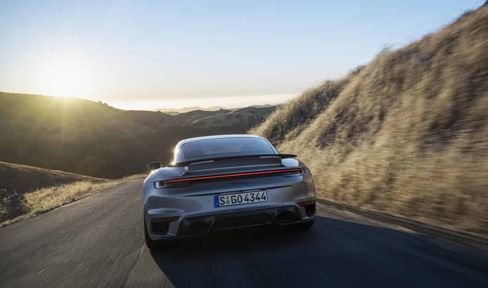 Introducing the Porsche 911 Turbo 50 Years model: Depicted here is a 911 Turbo 50 Years model's rubenesque rear end ambling on down the road. Credit: Porsche AG