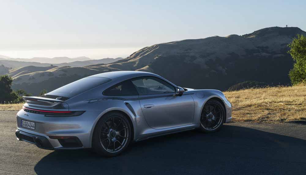 Introducing the Porsche 911 Turbo 50 Years model: Pictured here on a scenic hilltop is a 911 Turbo 50 Years model, right-rear, at rest, overlooking the view. Credit: Porsche AG