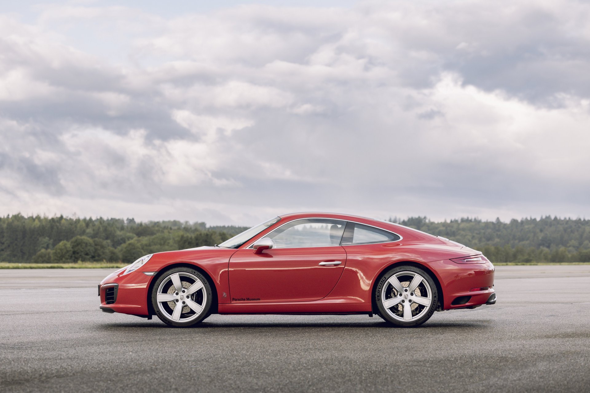 991.1-Gen Porsche 911 Buyer Guide: Pictured here is a Red 991.1 Coupe - left-side on tarmac. Credit: Porsche AG