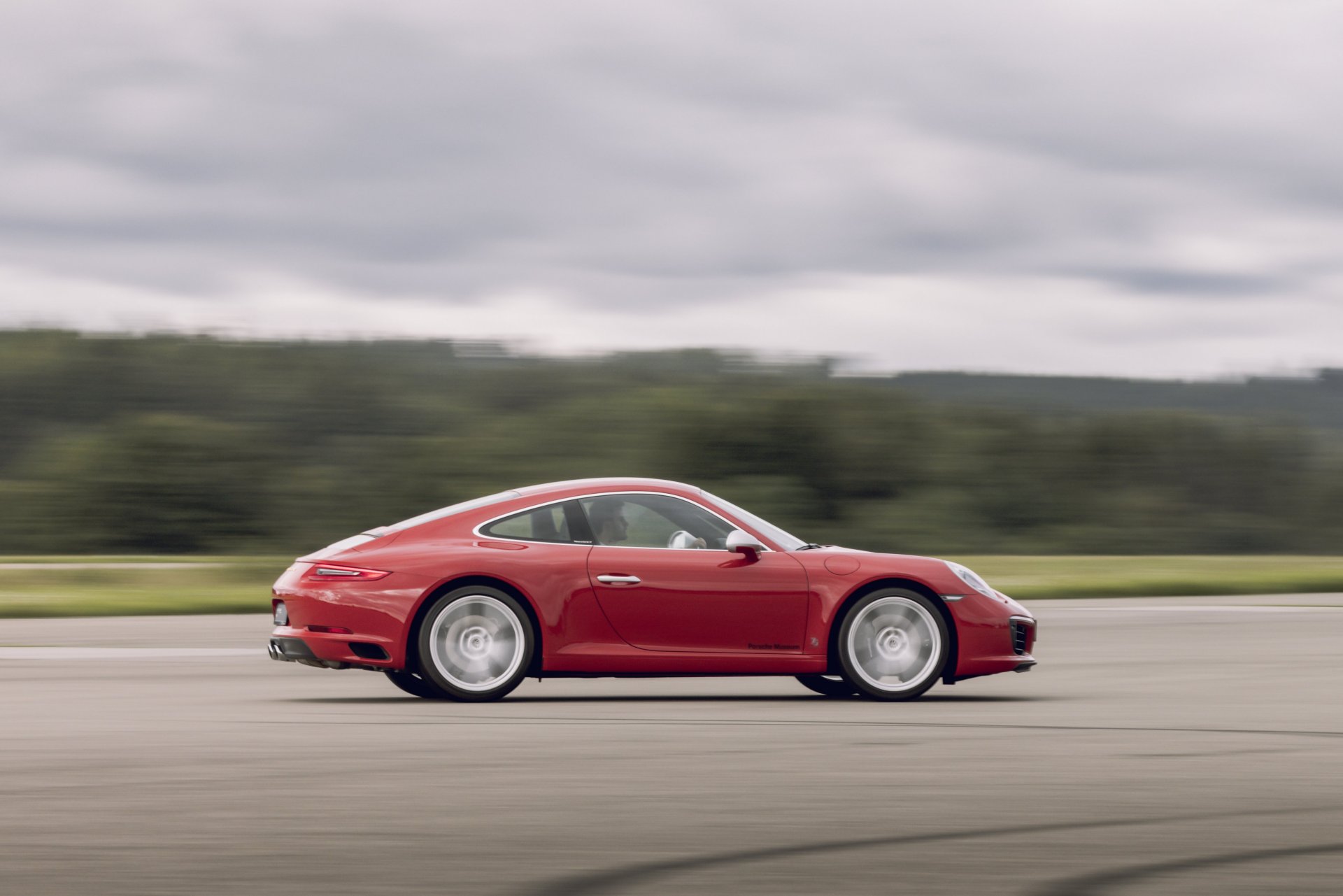 991.1-Gen Porsche 911 Buyer Guide: Pictured here is a Red 991.1 Coupe - right side on tarmac at speed. Credit: Porsche AG